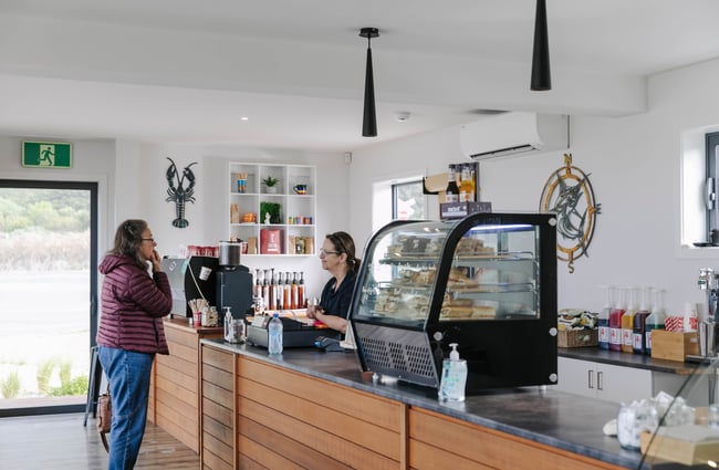 Woman ordering at the till at Karaka Lobster.