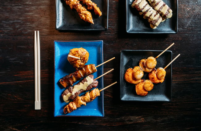 Yakitori skewers on a plate on the table at Kazu Yakitori & Sake Bar.