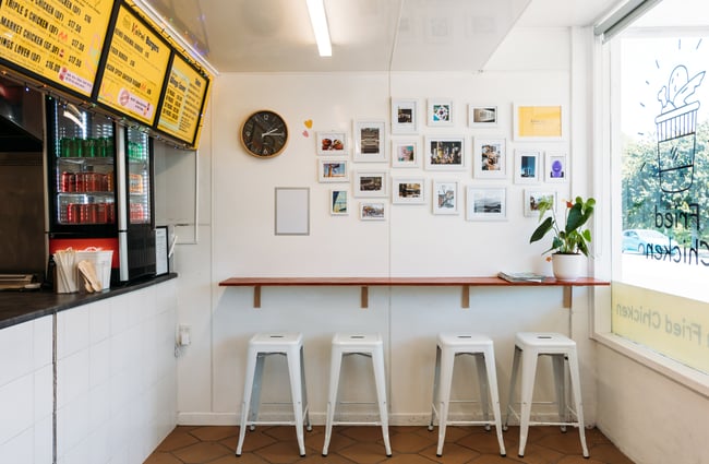 Bar stools along a white wall.