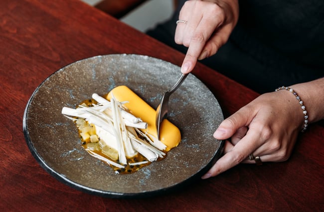 Customer using a spoon to eat a dessert at Kika.