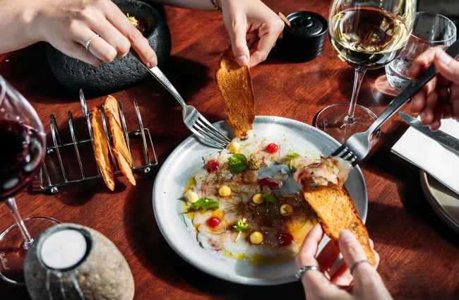 Customers sharing a dish on the table at Kika.