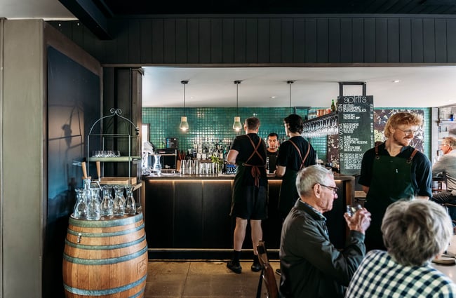 Looking towards the bar area inside kika with its teal tiled backdrop.