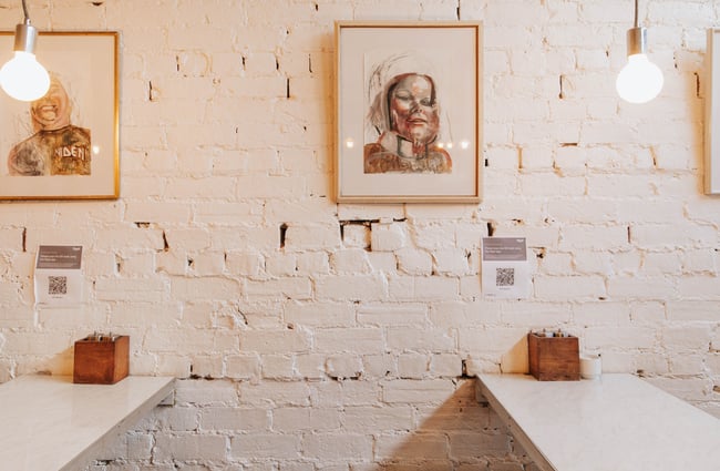 White tables against a painted-white brick wall.