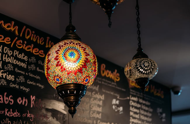 Close up of colourful glass Turkish lightshades hanging from ceiling