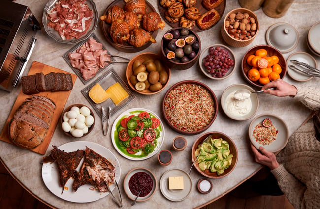 A birds eye view of many plates of food on a table.