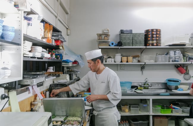 Inside the kitchen where the Chef in cooking food over the big grill.