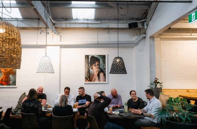 A large group of people chatting around a table at Kokomo in Christchurch.
