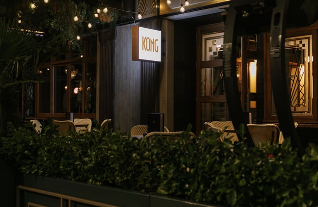 Outside terrace at nighttime with festoon lights and a 'Kong' sign lit up