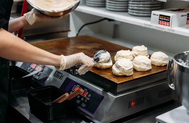 Chef in the kitchen, scooping out desserts at Kori Desserts.