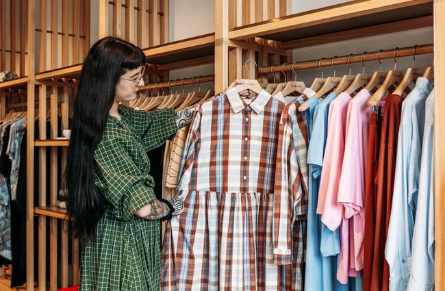 Shop assistant holding an item of clothing at Kowtow.