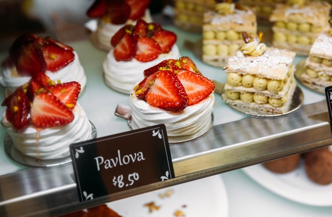 Mini pavlovas behind a glass counter.