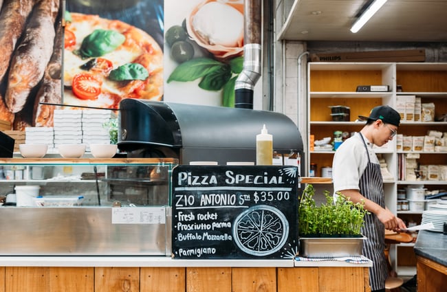 A blackboard sign promoting pizza.