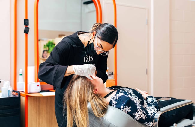 Beautician doing a woman's eyebrow treatment.