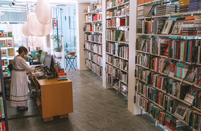 Interior view of Lamplight Books with woman working behind the counter.