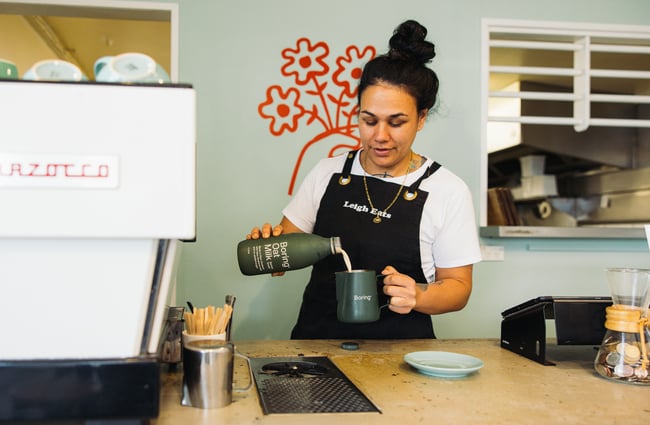 Barista pouring a coffee at Leigh Eats.