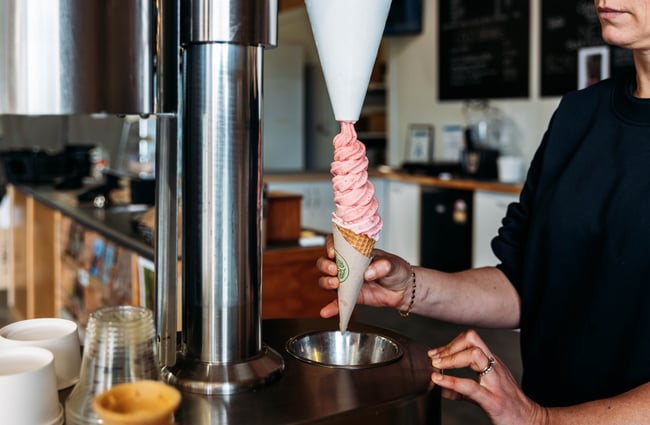 Staff member using the real fruit ice cream machine at Lewis Farms.