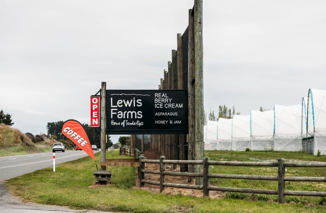 Large black signage outside the farmland of Lewis Farms.