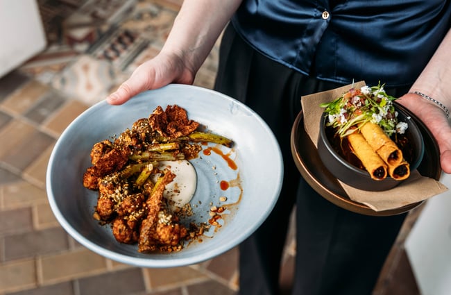 Wait staff delivering two plates of food at Libre.