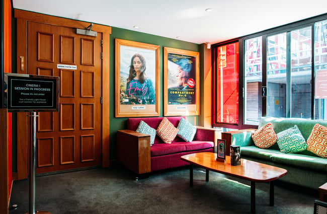 Colourful couches and posters on a wall.