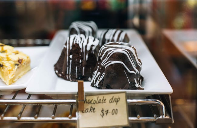 A close up of chocolate chip cake behind glass.