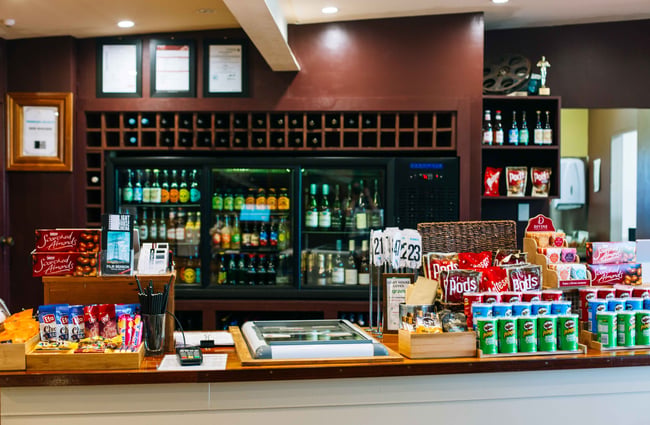 The bar counter full of drinks and treats.