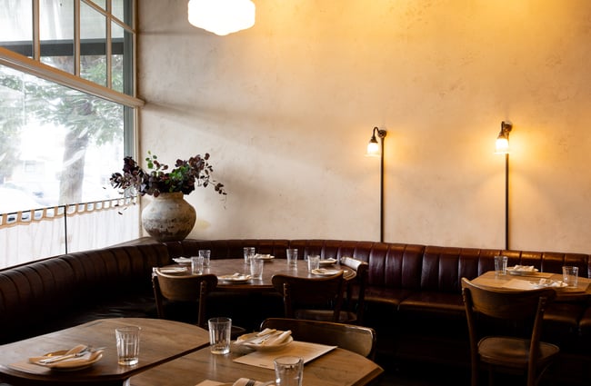A seating area by the front window at Lilian restaurant.