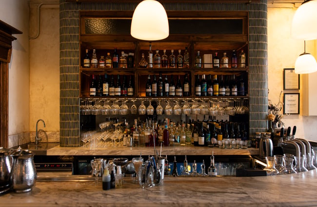 Bottles of wine and glasses behind the bar counter at Lilian.