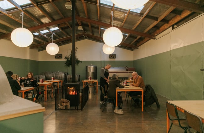 Customers sitting at tables inside a restaurant painted green.