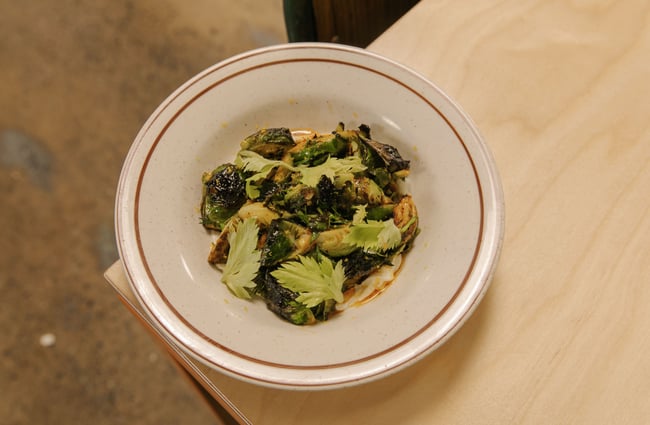 A plate of cooked broccoli on a table.