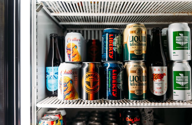 Canned beers stacked inside a fridge.