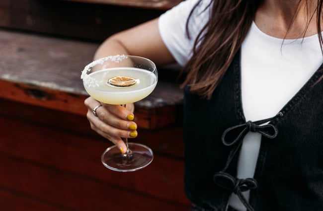 A hand holding a cocktail.