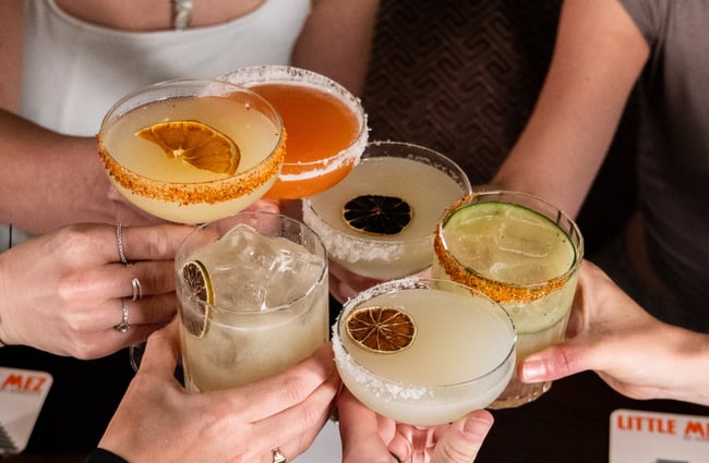 Glasses of cocktails being held up.