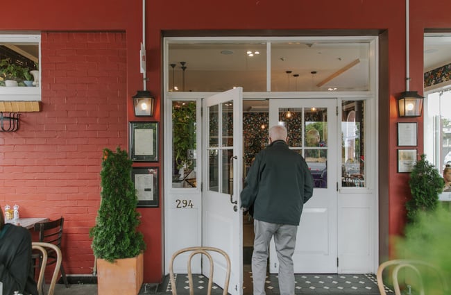 An elderly man walks into Little Pom's café, Christchurch.