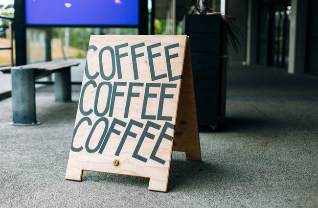 Coffee signs outside on the pavement.