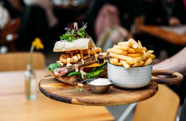 A plate with a large sandwich and fries at LOCAL.