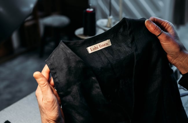 Hands holding a black vest.