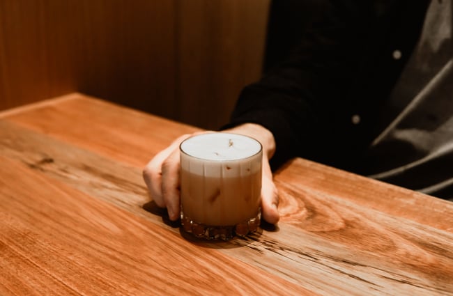 A hand holding a cocktail.