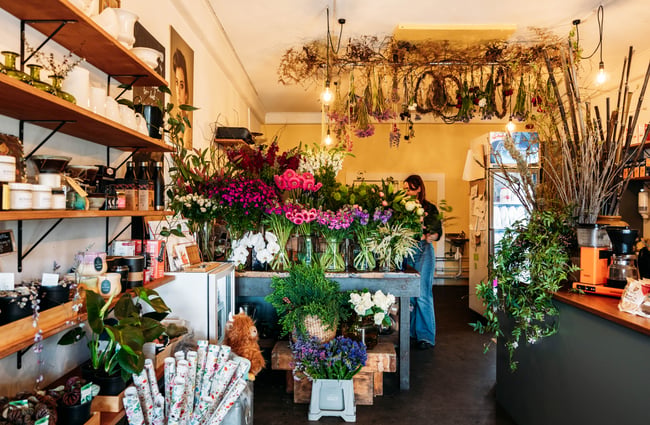 Flower arrangements are placed around the interior of the store at Love Stomp.