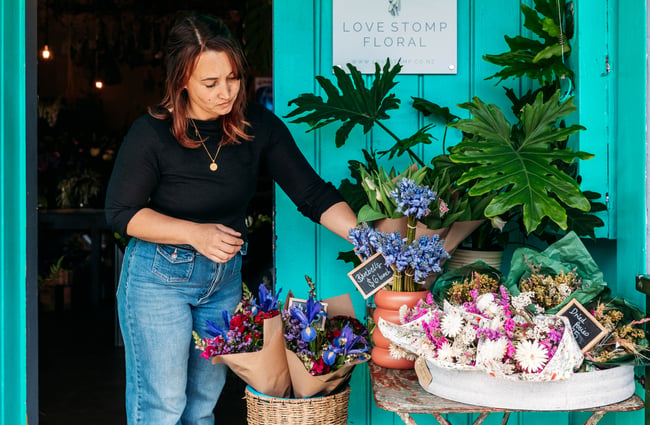 Owner places flowers outside the front door at Love Stomp.