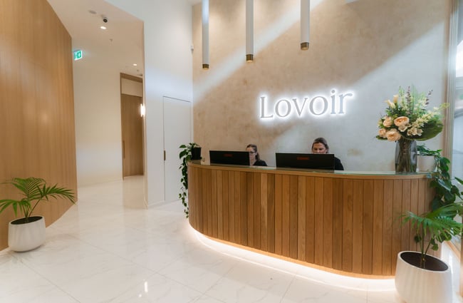 Two staff members working behind a counter at a day spa.