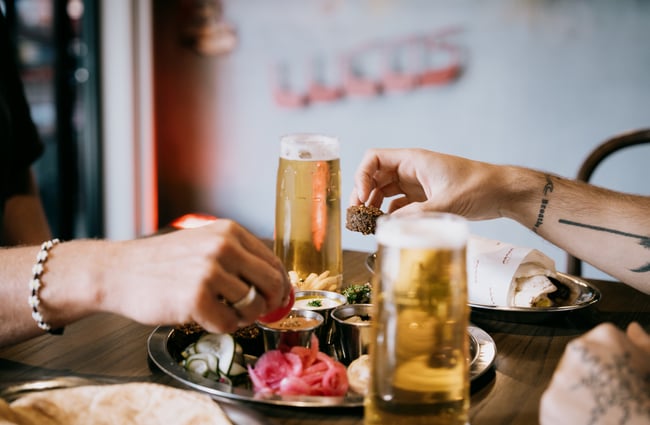 Hands reaching for mezze platter at Lucas at Little High Eatery in Christchurch