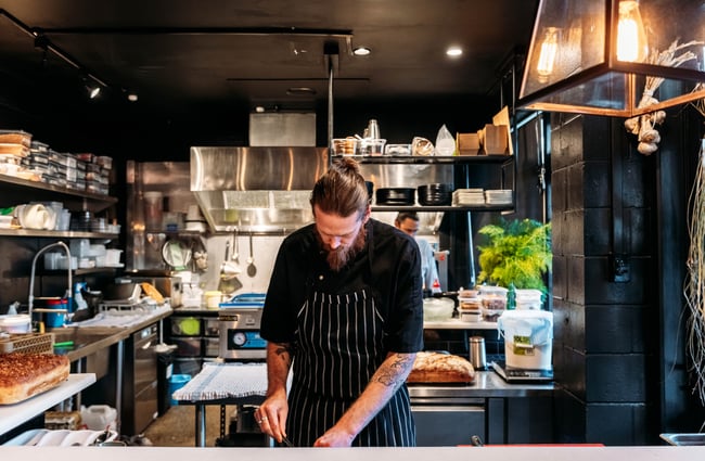 In the kitchen a chef is preparing a meal at Lustre.