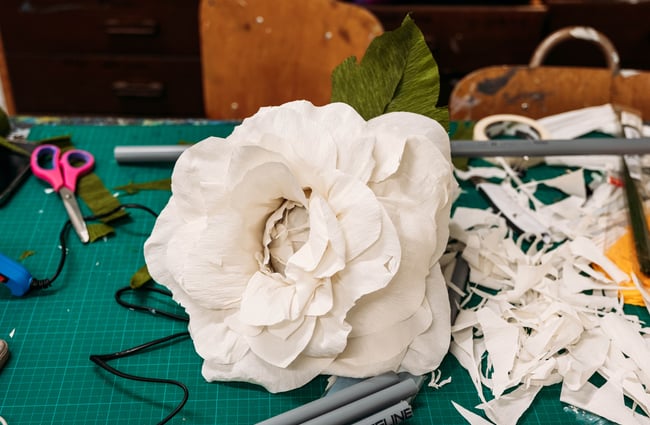 Close up of white flower on workshop desk constructed from crepe paper
