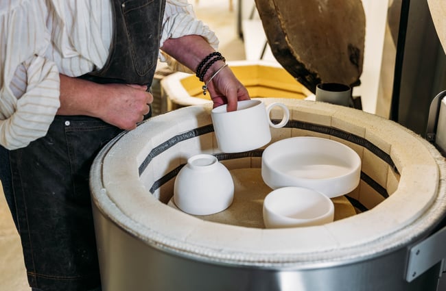 Ceramicist selecting items from the kiln at Mabel Vickers.