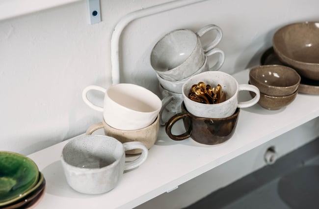 A collection of ceramic mugs are on shelves at Mabel Vickers.