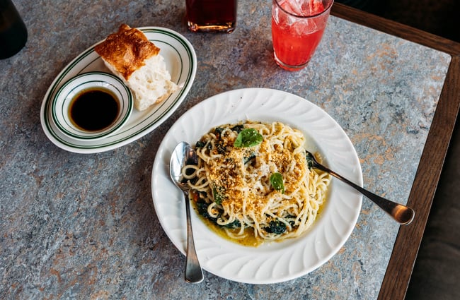 A plate of spaghetti with drinks on the table at Made.
