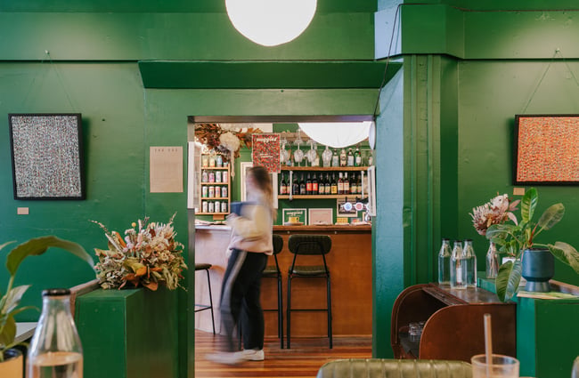A female customer walking behind the front counter inside Maggies Dunedin.