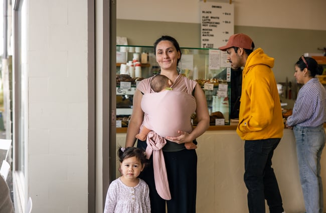 A woman and her children smiling at the camera.