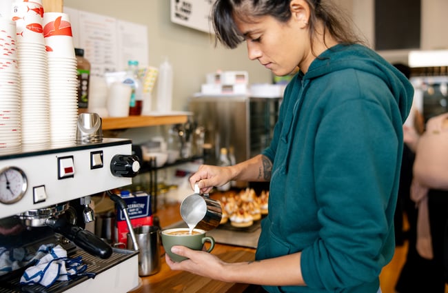 A staff member making coffee.