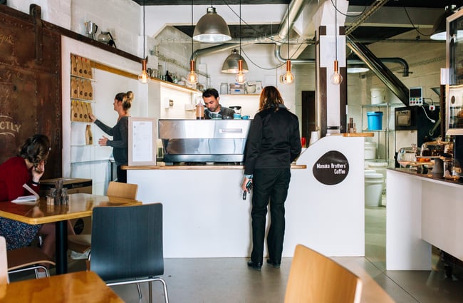 Customer waits at counter at Manuka Brothers, Hamilton.
